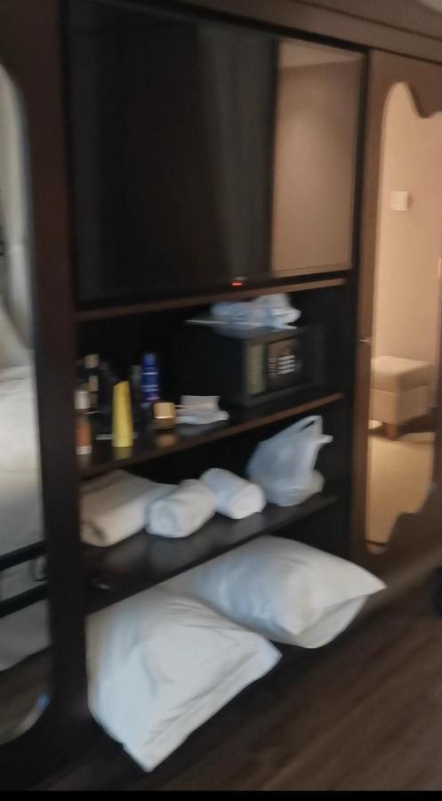 Buona Vitta Gramado Resort & Spa By Gramado Parks Buitenkant foto The photo shows a piece of furniture, likely a shelving unit or cabinet, with several items on it. There is a television mounted on top. Below the TV, there is a microwave and a small safe. The shelves contain various toiletries and personal care pro