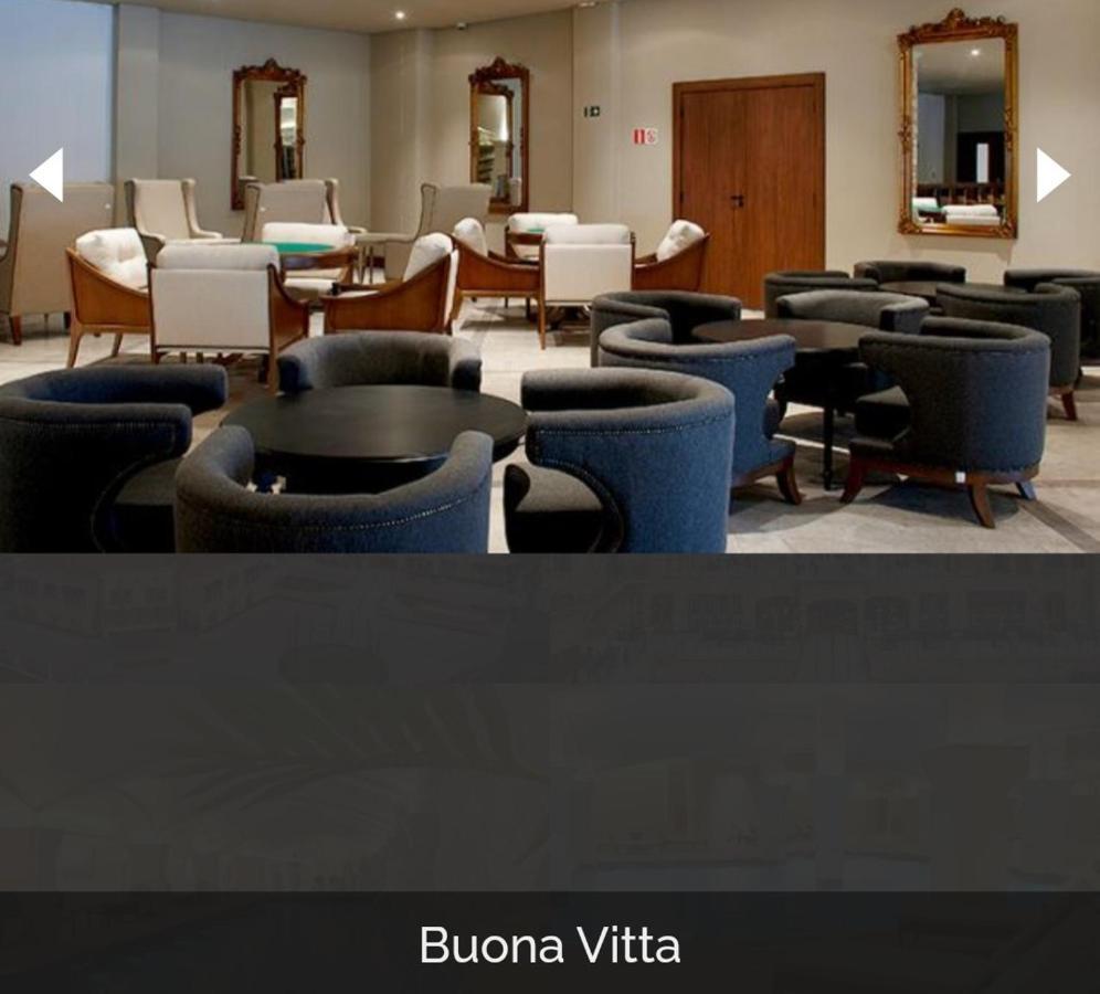 Buona Vitta Gramado Resort & Spa By Gramado Parks Buitenkant foto The photo shows a modern, elegantly designed lounge or waiting area. It features several circular seating arrangements with dark blue armchairs surrounding black tables. In the background, there are light-colored lounge chairs and a wooden door leadi