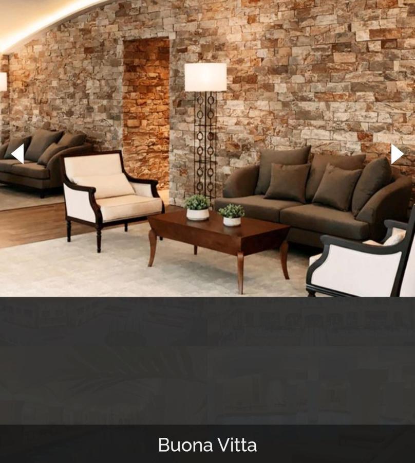Buona Vitta Gramado Resort & Spa By Gramado Parks Buitenkant foto The image shows a stylish living room setting. There are two sofas: one is a dark brown color, and the other is a cream color with dark wooden accents. In the center, there is a wooden coffee table with a smooth finish and decorative plants on top. T