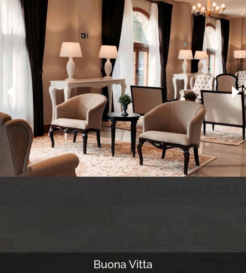 Buona Vitta Gramado Resort & Spa By Gramado Parks Buitenkant foto The photo shows a stylish and inviting interior space, likely a lounge or waiting area. There are beige upholstered armchairs arranged around a small black table. A decorative plant is placed on the table. Behind the chairs are light-colored walls wi