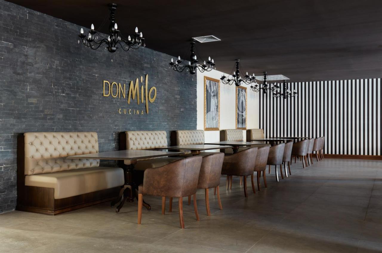 Buona Vitta Gramado Resort & Spa By Gramado Parks Buitenkant foto The photo showcases an interior of a restaurant named "Don Milo." The design features a modern and sophisticated look with a mix of textures and colors. 

On one side, there are upholstered booths in a neutral tone, creating a comfortable dining area