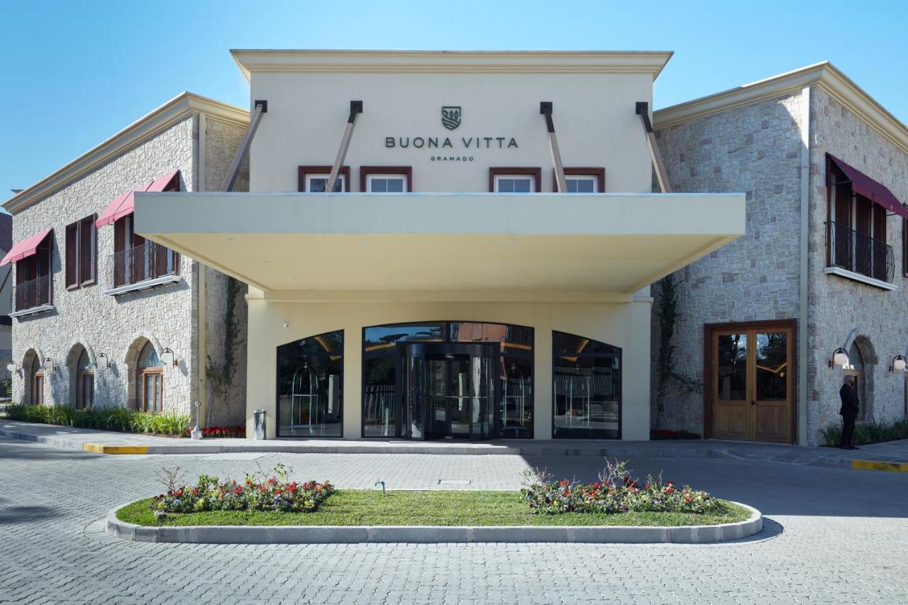 Buona Vitta Gramado Resort & Spa By Gramado Parks Buitenkant foto The photo shows a modern building with a prominent entrance marked by a large awning. The facade features a mix of stone and stucco materials, giving it an elegant and contemporary look. The name "BUONA VITTA" is displayed prominently above the entra